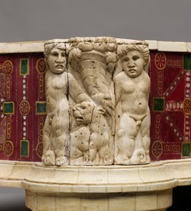 Dettaglio del poggiapiedi con intaglio osseo di cupidi, leopardi e cornucopie